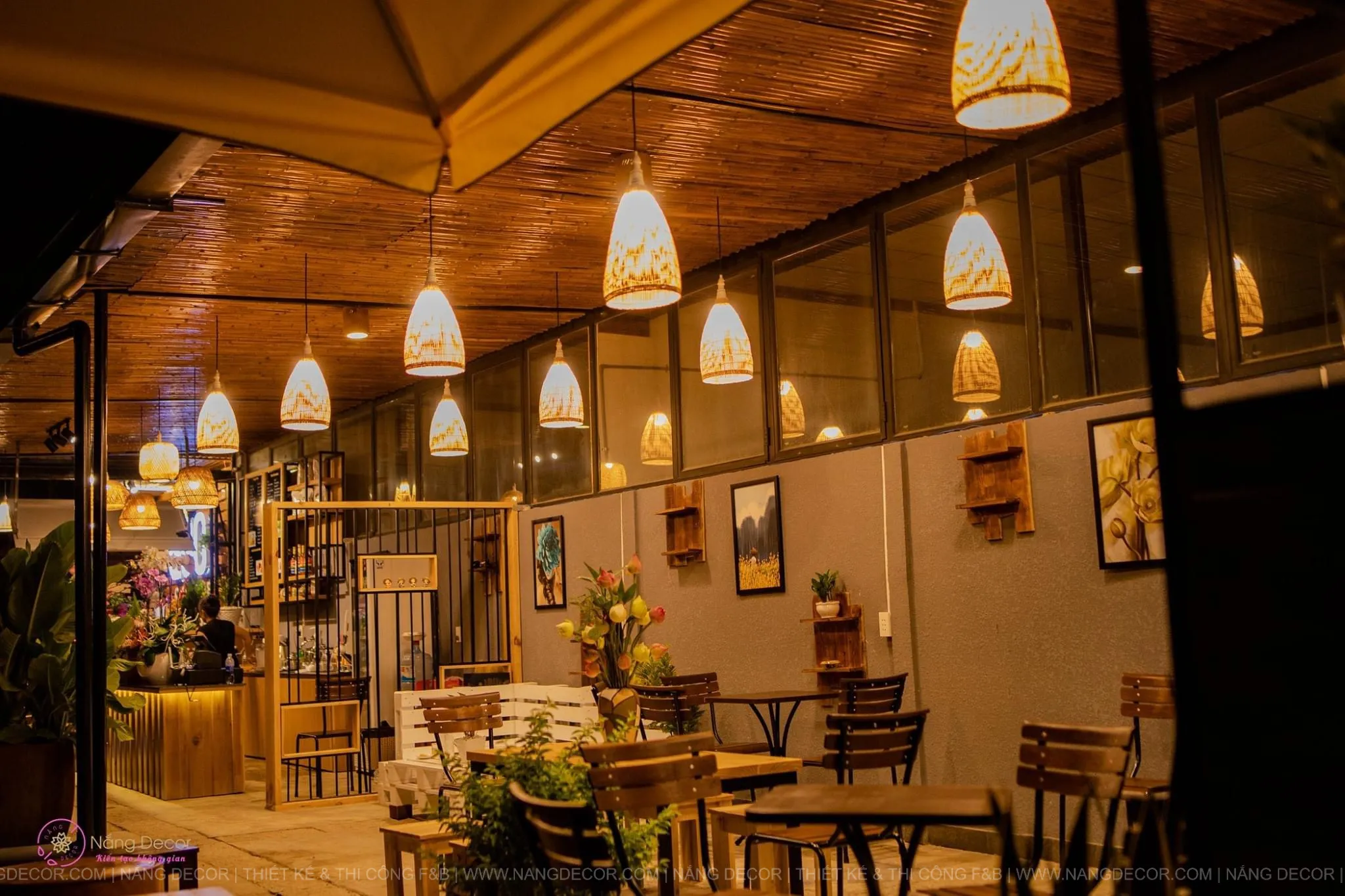 Thiết kế quán cafe nhỏ phong cách Japandi với nội thất gỗ sáng màu và cây xanh.