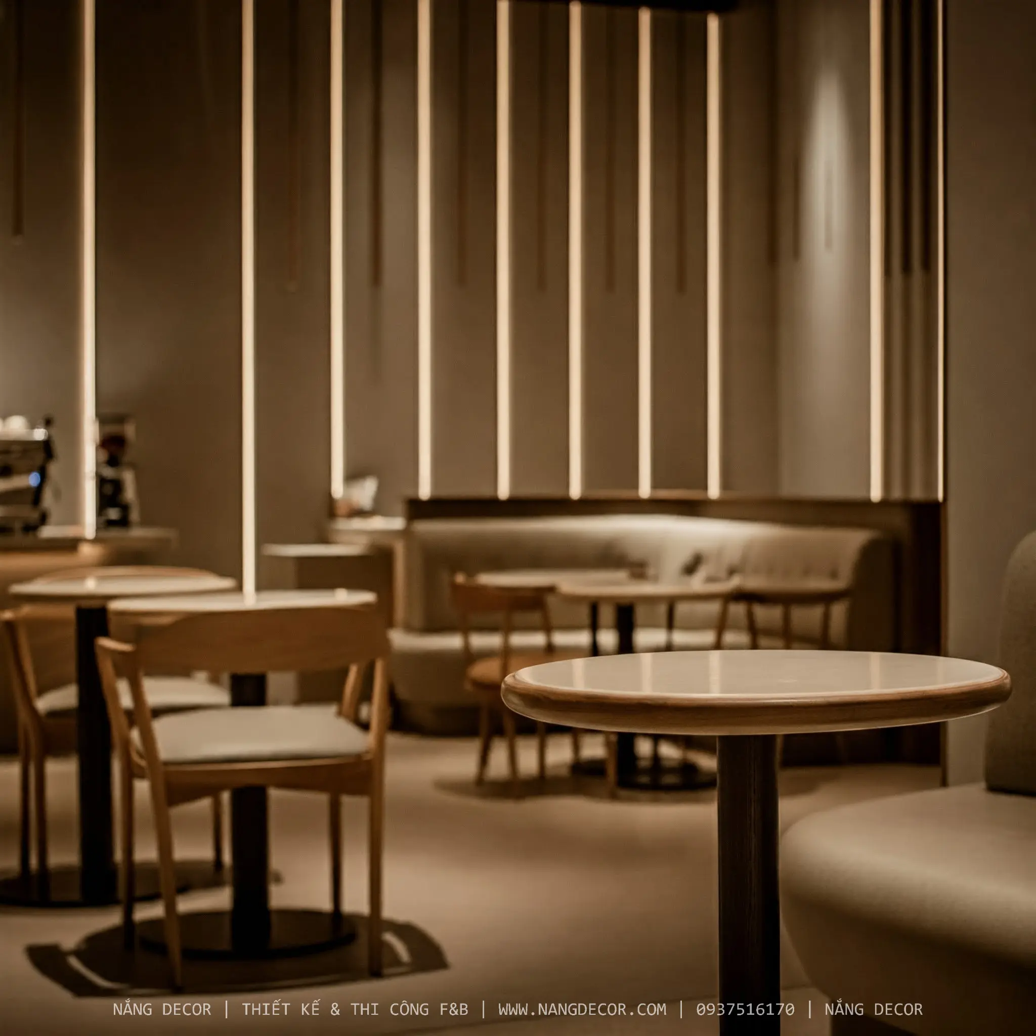 Quán cafe sân vườn phong cách Địa Trung Hải với tường trắng và cây xanh.