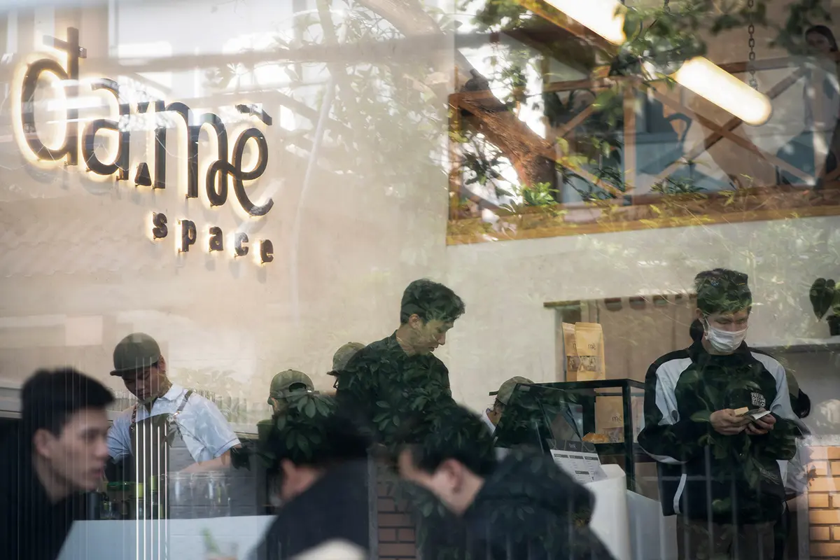 Hệ thống đèn trang trí tạo không gian ấm cúng cho quán cafe vỉa hè vào buổi tối.